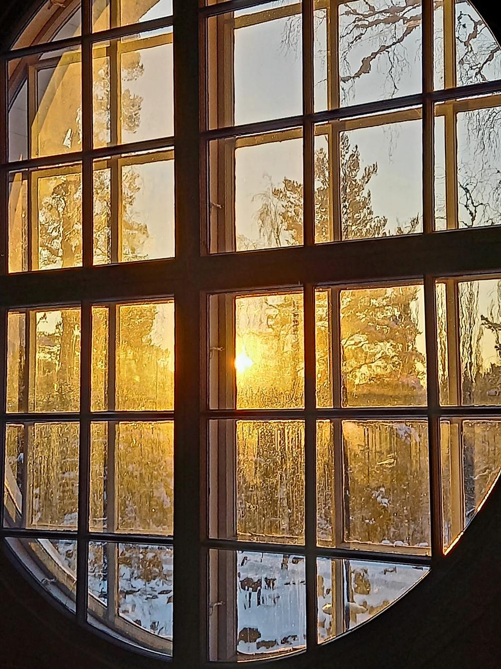 Pyöreästä ikkunasta kajastaa auringonvalo